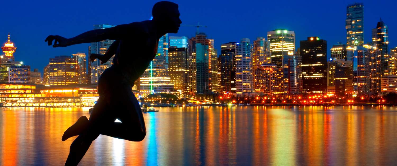 Silhouette of a sprinter in motion at dusk with illuminated city skyline and water reflection, highlighting urban fitness trends and active lifestyles.